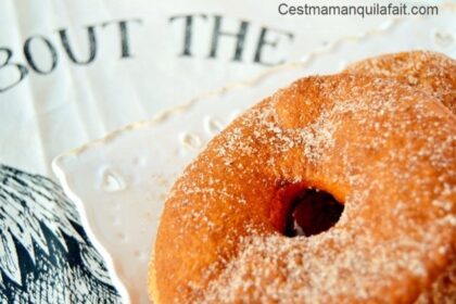 Beignets ronds et moelleux saupoudrés de sucre, empilés les uns sur les autres pour une présentation gourmande.